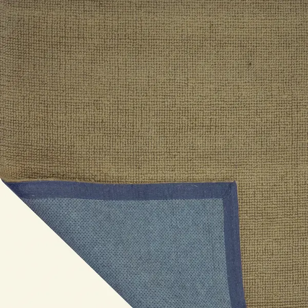 Corner detail of Sandstone Brae Jute Rug showing blue binding and backing