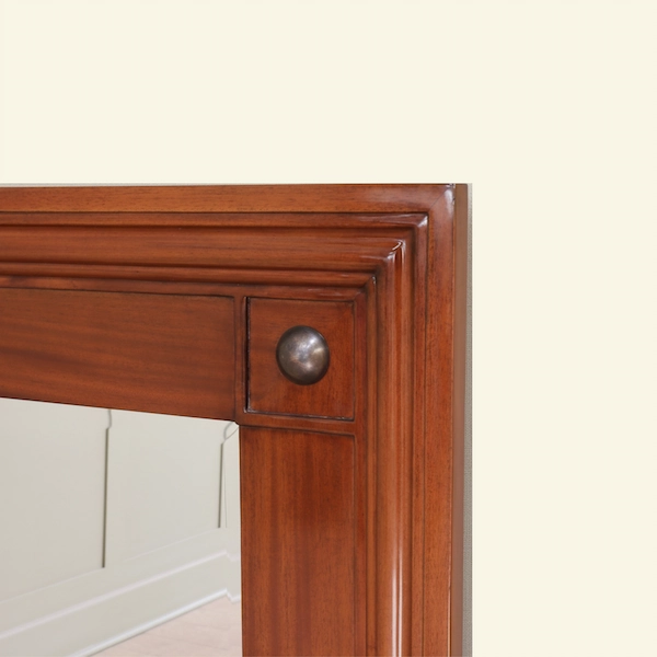 Equestrian Manor Mirror Corner Detail with Brass Medallion Close-up of the Equestrian Manor Mirror showing stepped mahogany frame with brass medallion corner detail.