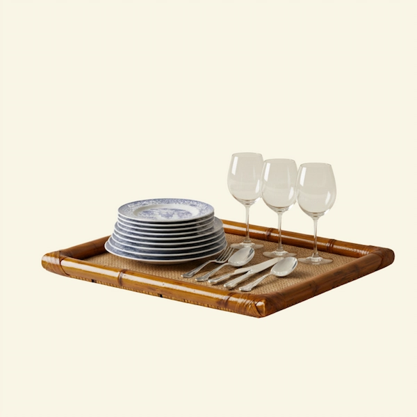 Laguna Rattan & Bamboo Tray Styled with Dinnerware Large woven rattan bamboo serving tray styled with plates and wine glasses on a table.