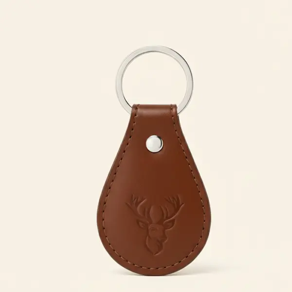 Front view of the Stag Crest Leather Key Ring in Cognac Brown on a cream background.