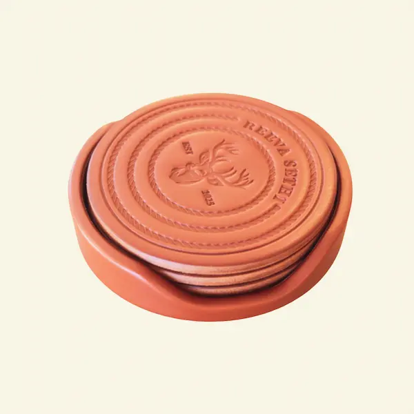 Stag Crest Leather Coaster Set with Holder – Side View Side view of saddle brown leather coaster set with embossed stag crest, housed in matching leather holder