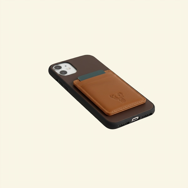 tag Crest Saddle Tan Magnetic Leather Card Case – Lifestyle with Card and Phone Stag Crest Saddle Tan Magnetic Leather Card Case holding card beside phone