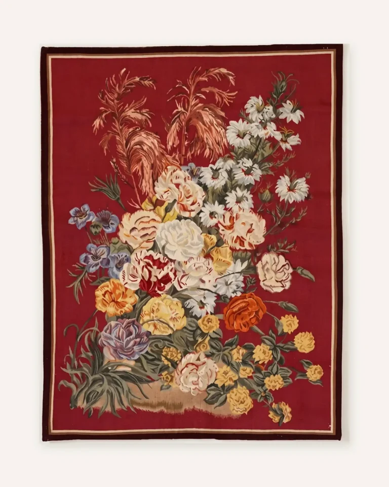 Crimson Bouquet handwoven wool tapestry with a full bouquet of roses, daisies, blue flowers and pink plumes on a crimson ground inside a striped border
