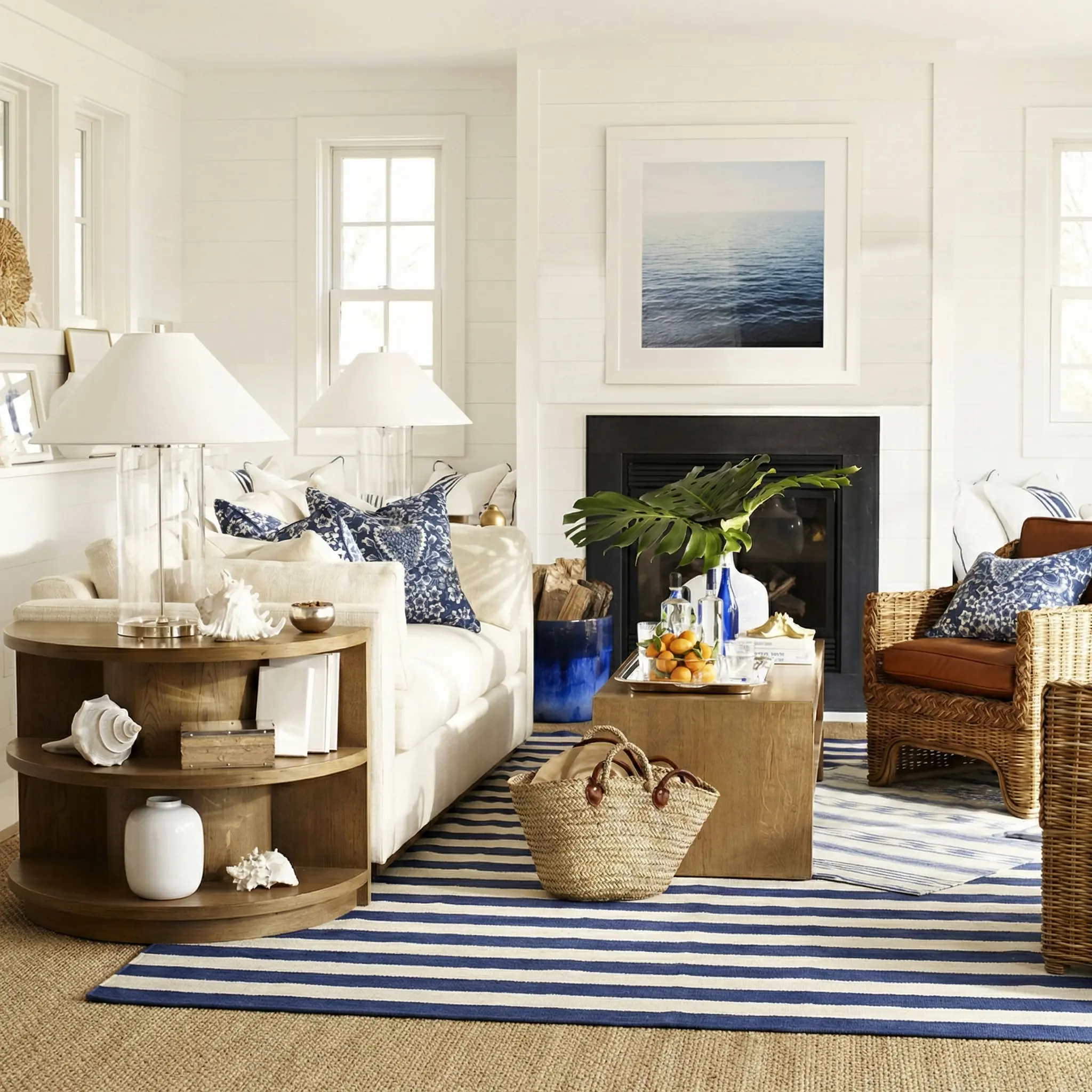 A brown wicker armchair styled in a bright Bay Area living room with a white sofa and blue patterned pillows for a coastal look