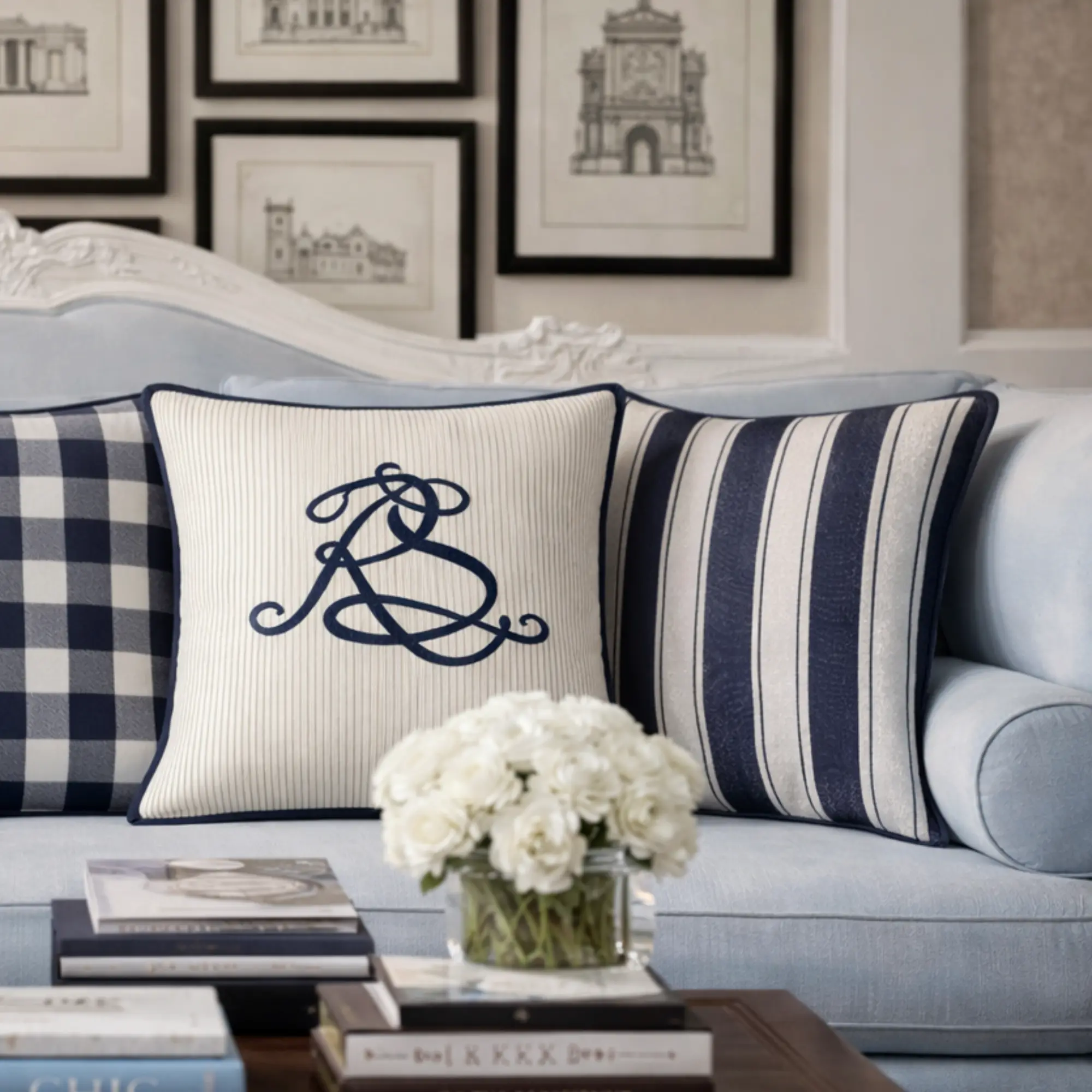Navy pinstripe cotton throw pillow with embroidered script monogram styled on a tailored sofa