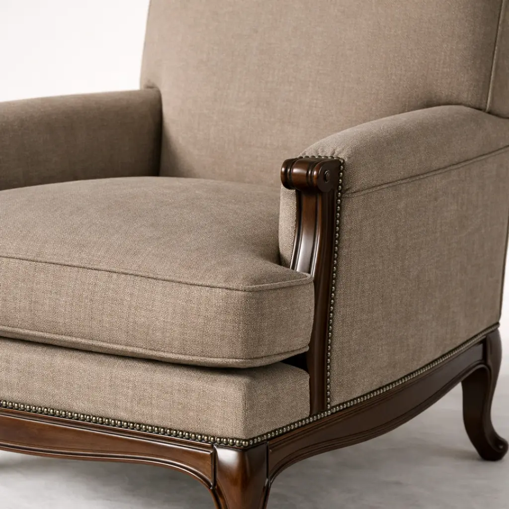 Close-up detail of Montreux bergère chair arm: hand-carved mahogany joinery meeting tailored upholstery seam — demonstrating quality craft at RS Studio Saratoga