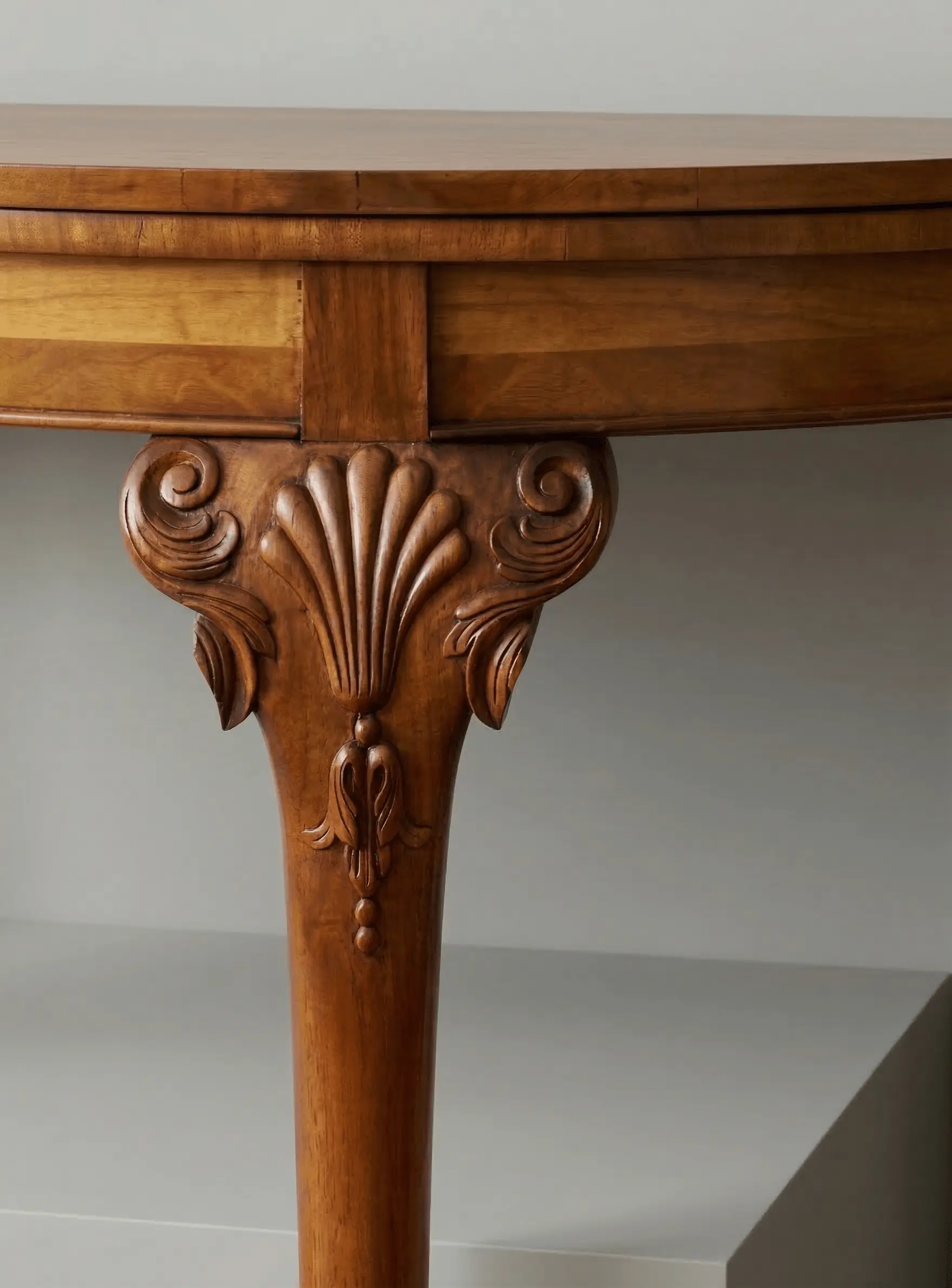 Close-up of hand-carved wooden furniture leg with shell motif and scroll carving