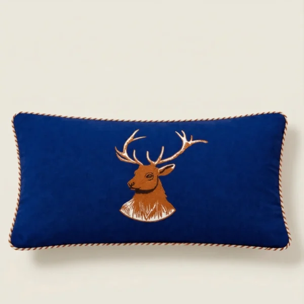 Navy lumbar pillow with embroidered stag design and piping