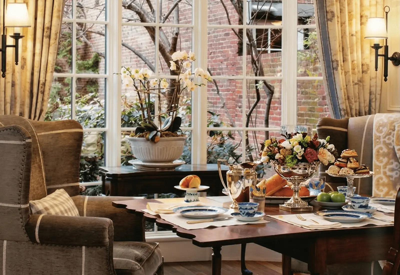 Traditional dining room with antique wood table set beside large windows
