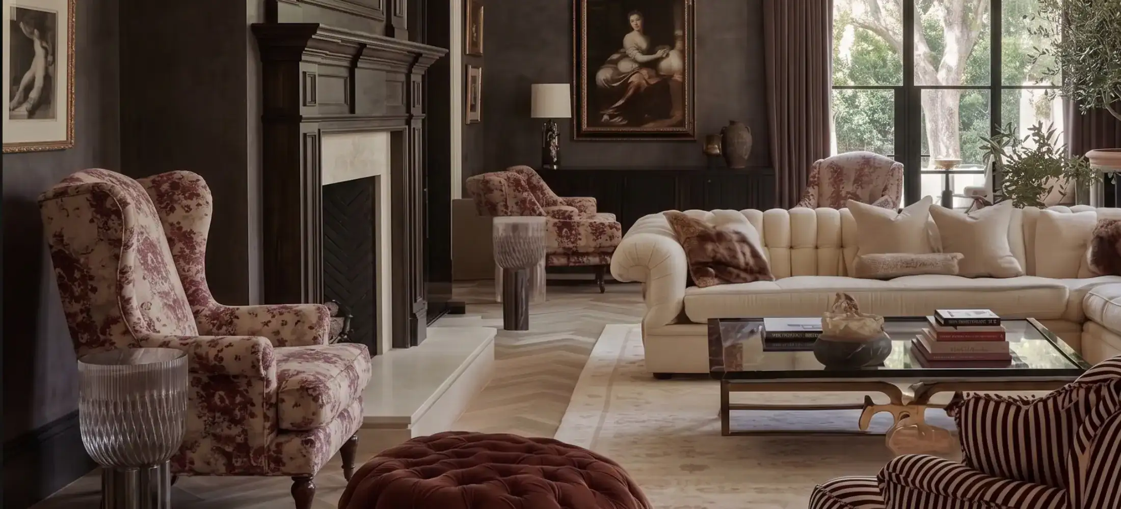Wingback chairs in layered interior with fireplace and arched windows
