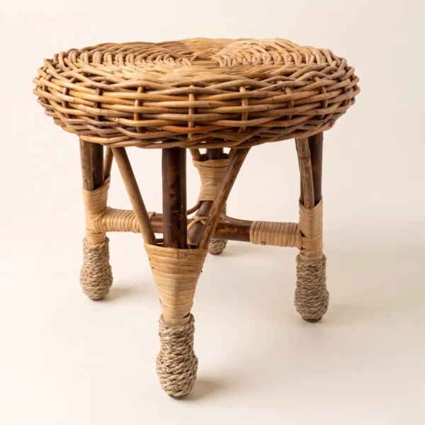 Side angle view of the Hawthorne handwoven rattan stool with braided seat and wrapped legs.