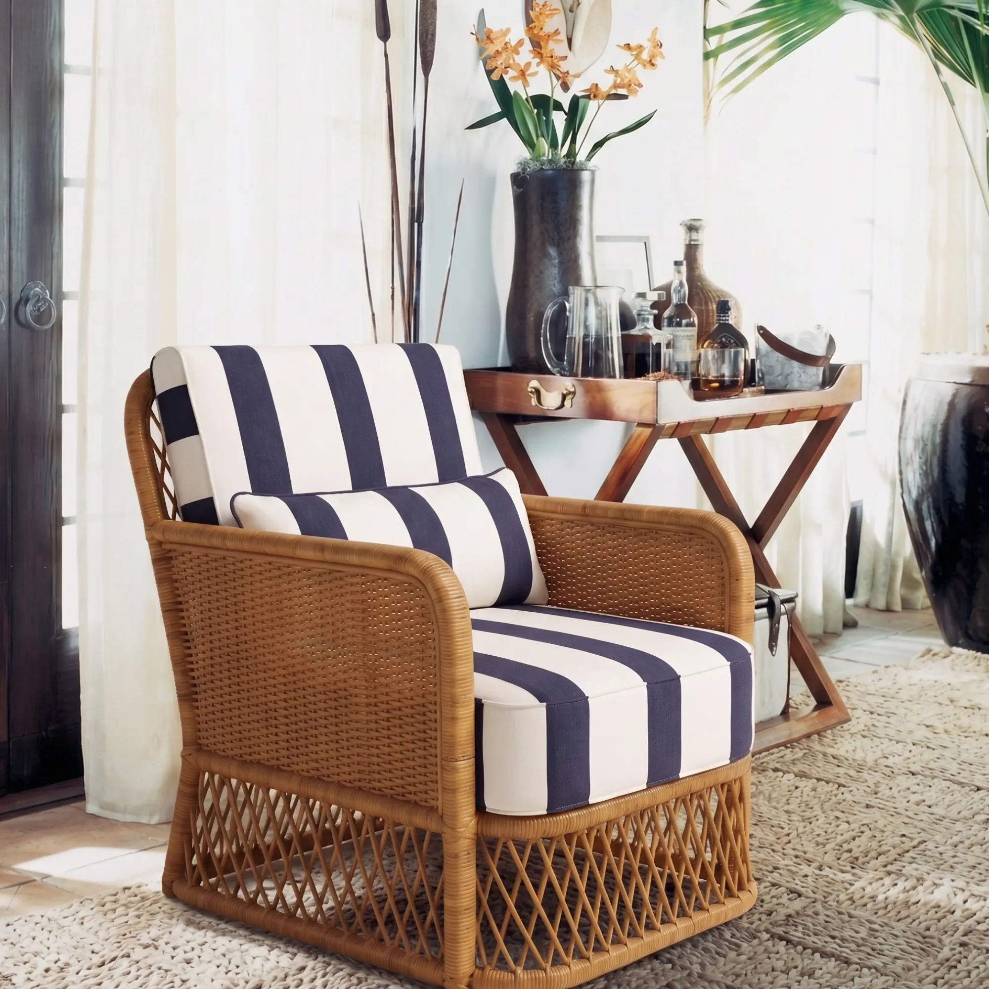 Montauk Cabana Lounge Chair 6 Montauk Cabana Lounge Chair styled in a sunroom with navy ivory striped cushions, woven rattan frame, and warm natural light