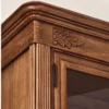 Close-up of a handcrafted mahogany cabinet with carved wood detailing, fluted corner columns, and a warm hand-rubbed finish.